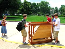 Students carrying small Rathke organ outside